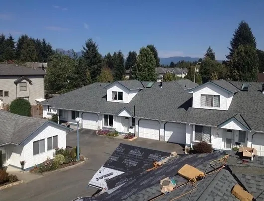 Connected townhouse units with matching grey shingle roofs